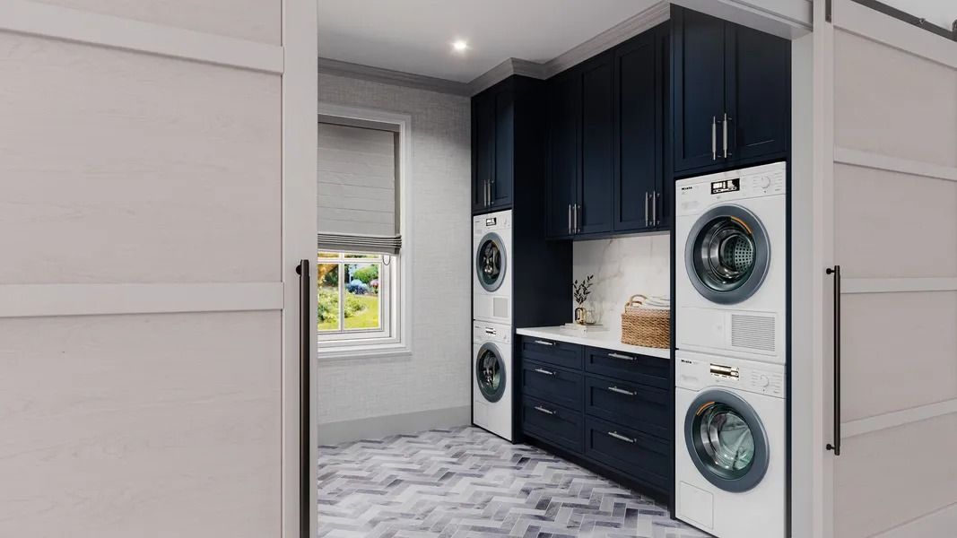 Laundry room with stacked washer/dryer, navy cabinets, and sliding doors.