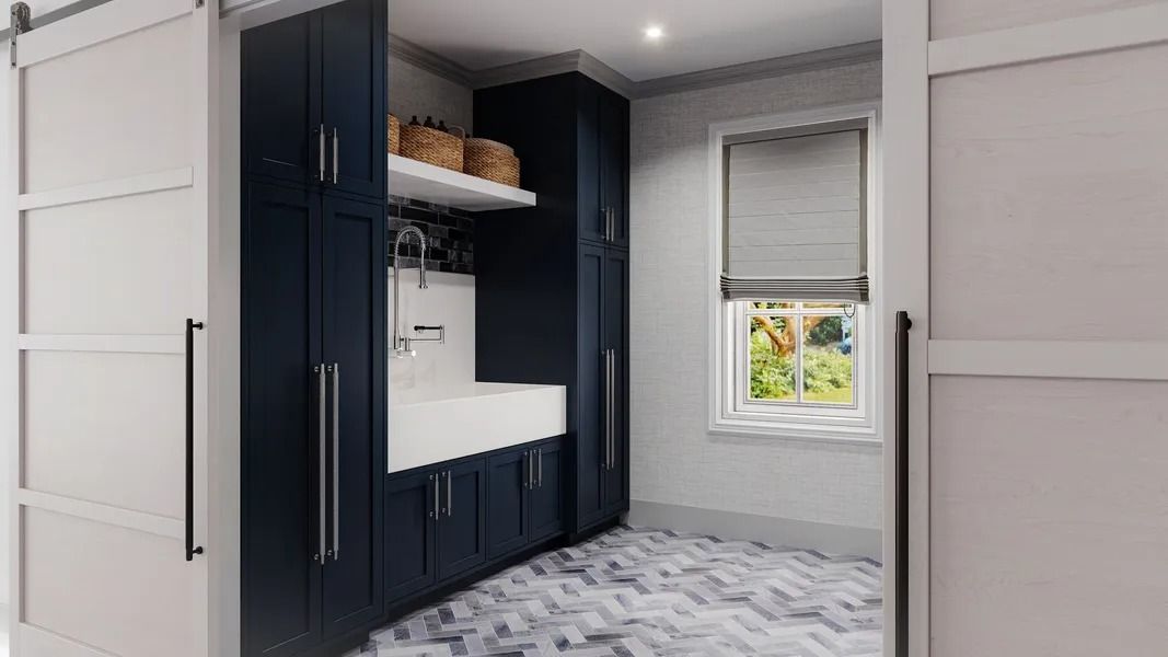 Laundry room with navy cabinets, white sink, and sliding doors.