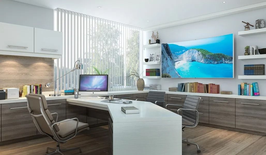 Modern office with a white desk, computer, and large screen displaying an ocean view.