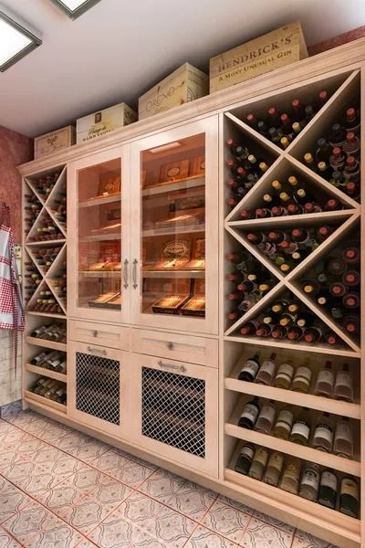 Wine cellar with wooden storage; angled racks, glass-door cooler, drawers, and stacked boxes.