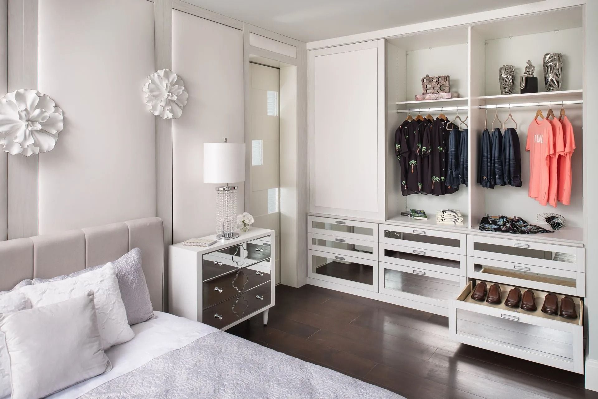 White bedroom with walk-in closet; bed, nightstand, and wardrobe, neatly organized clothes and shoes.