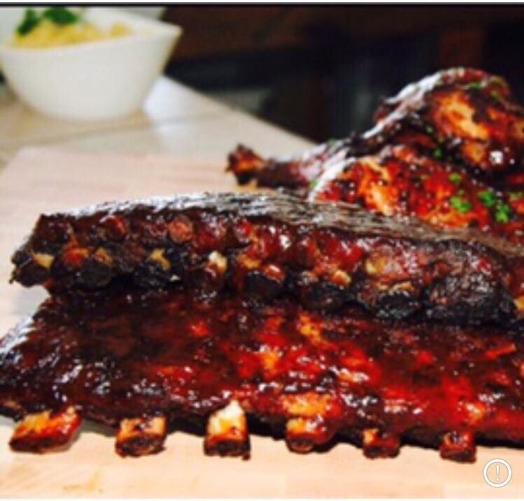 Rack of BBQ ribs and chicken with sauce.