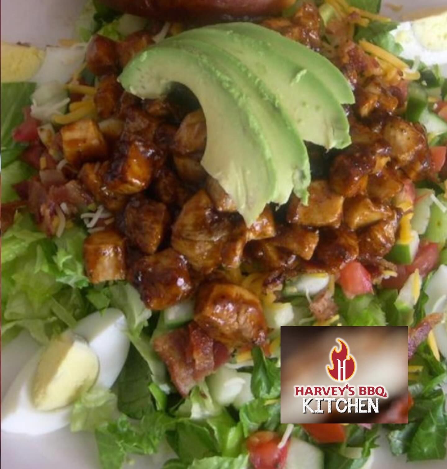 Barbecue chicken salad with avocado, bacon, eggs, and lettuce, branded by Harvey's BBQ Kitchen.