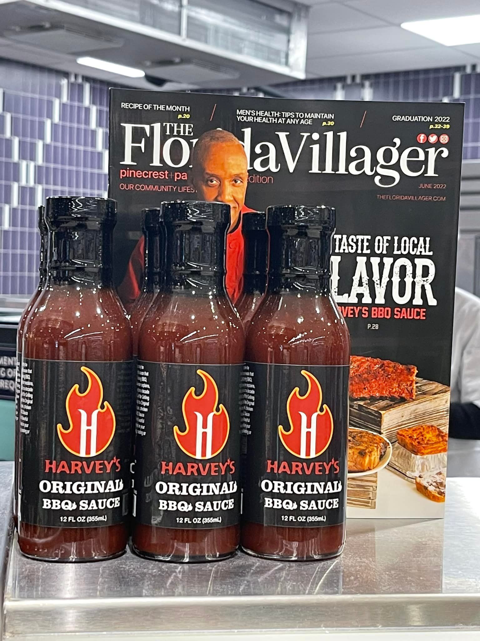 Bottles of Harvey's Original BBQ sauce in front of a magazine. The magazine has a photo of a man and food.