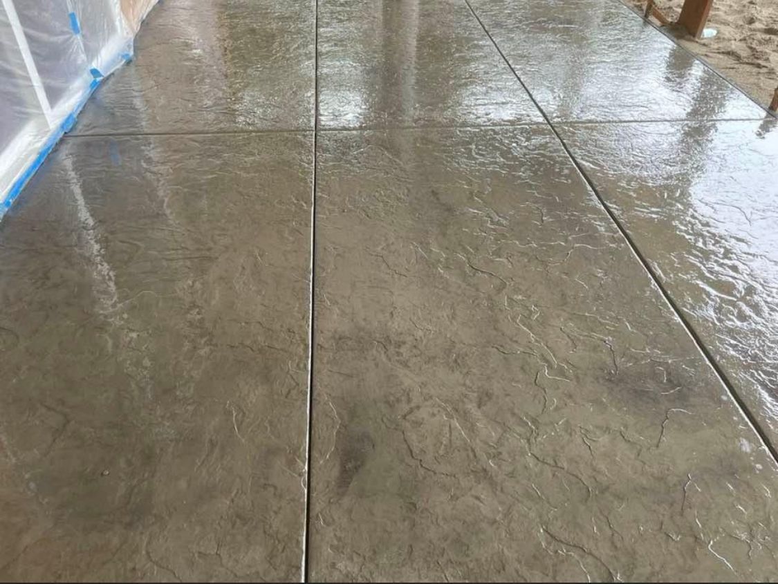 Wet, textured concrete patio with rectangular panels. Gray color.