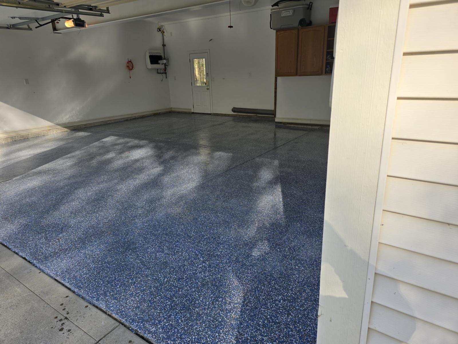 A garage with a blue floor and white walls.