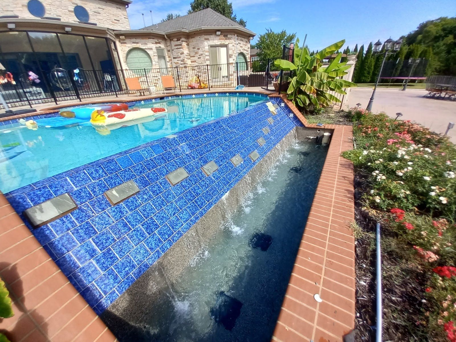 A large swimming pool with a waterfall in the middle of it