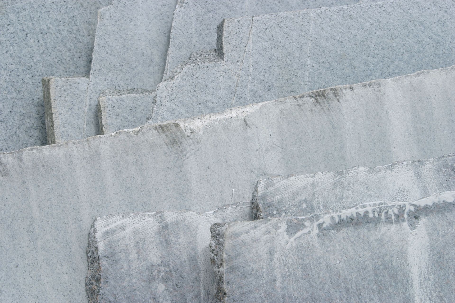 Gray stone steps or terraces with a rough, weathered texture in close-up.