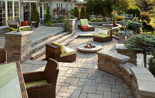 Stone patio with lounge furniture, fire pit, and landscaping.