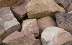 Pile of various-sized, multi-colored rocks: beige, tan, and reddish-brown.