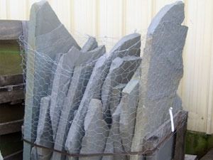 Gray stone slabs bundled in wire mesh.