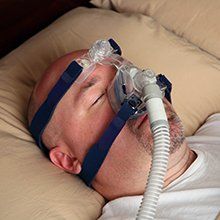 man lying in bed with sleep apnea