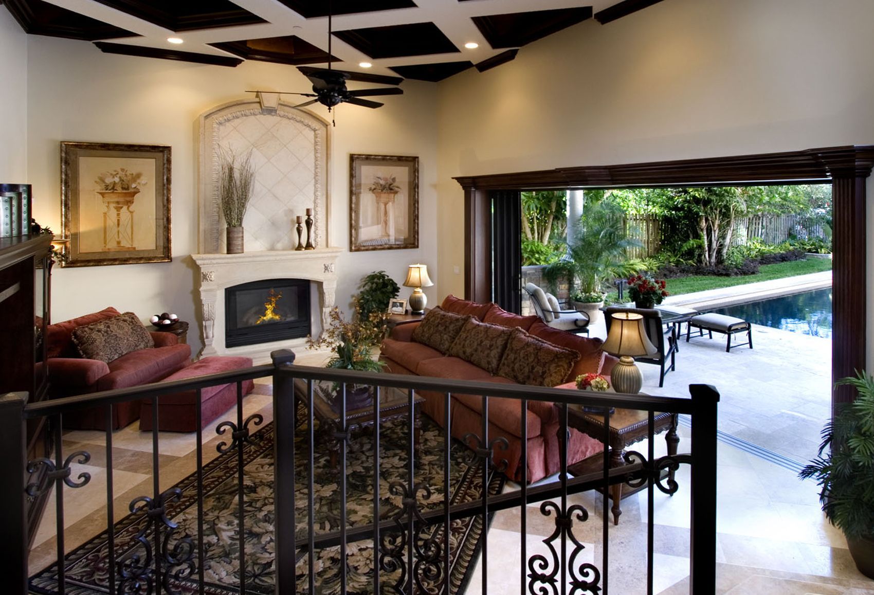 A living room with a fireplace and a view of a pool