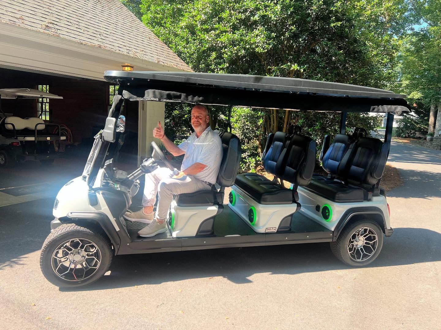 A man is sitting in a white golf cart.