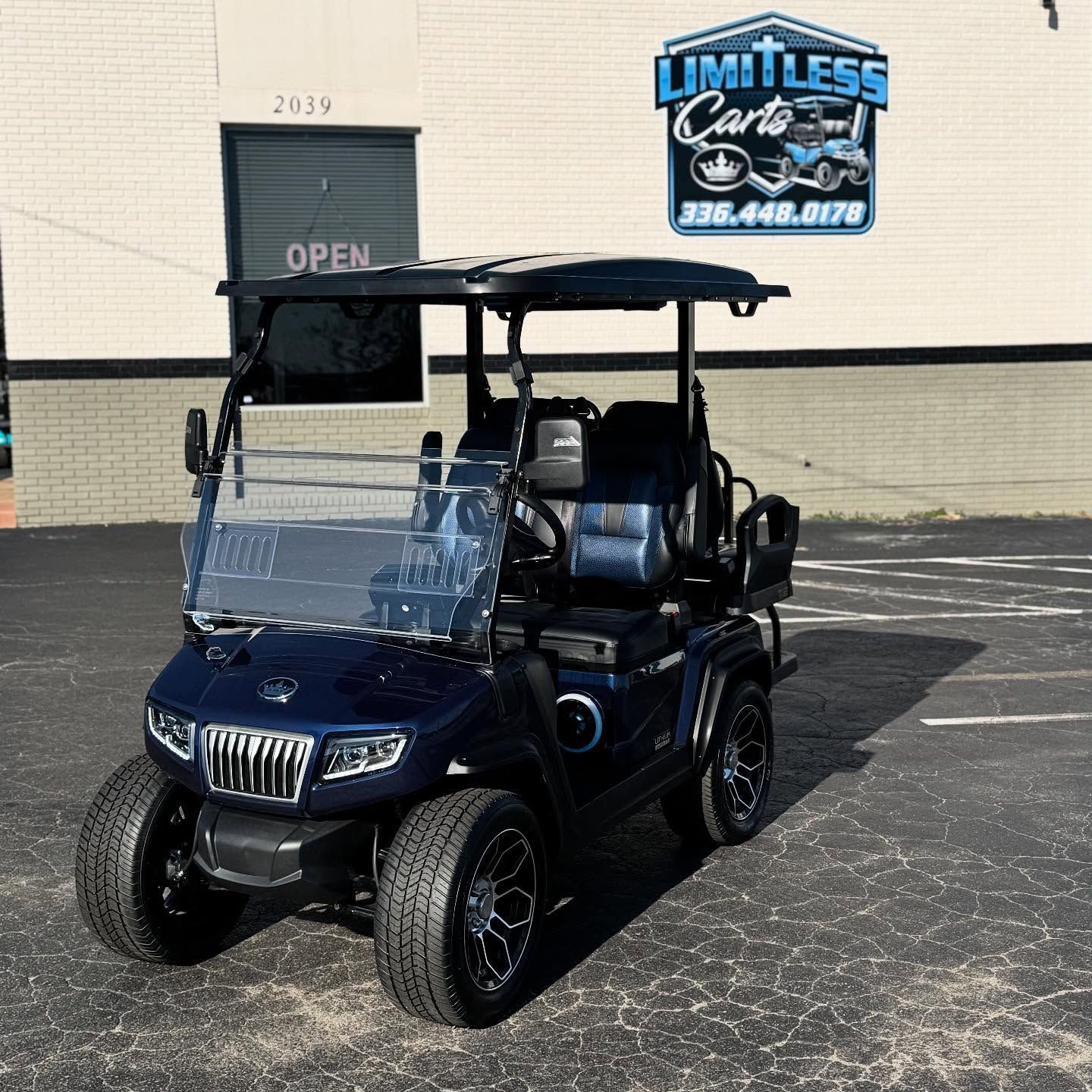 A blue golf cart is parked in front of a building.