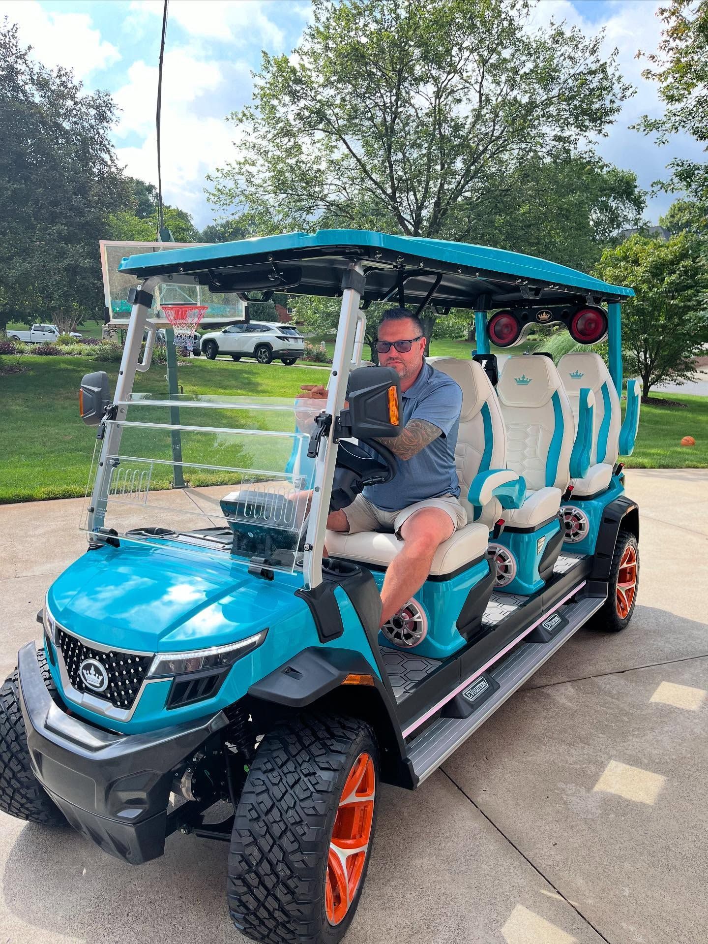 A man is sitting in a blue golf cart.