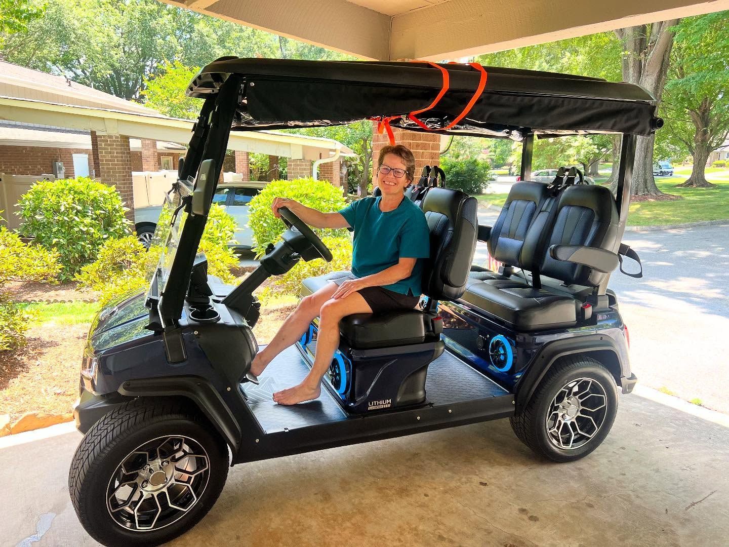 A young boy is sitting in a golf cart.