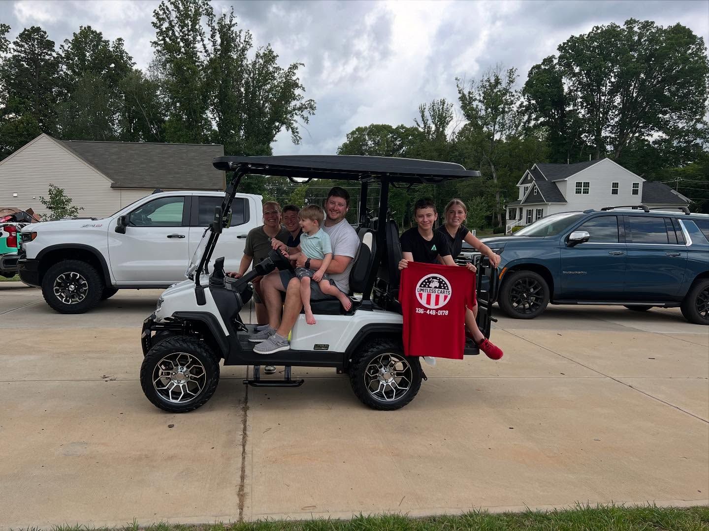 A group of people are sitting in a golf cart.