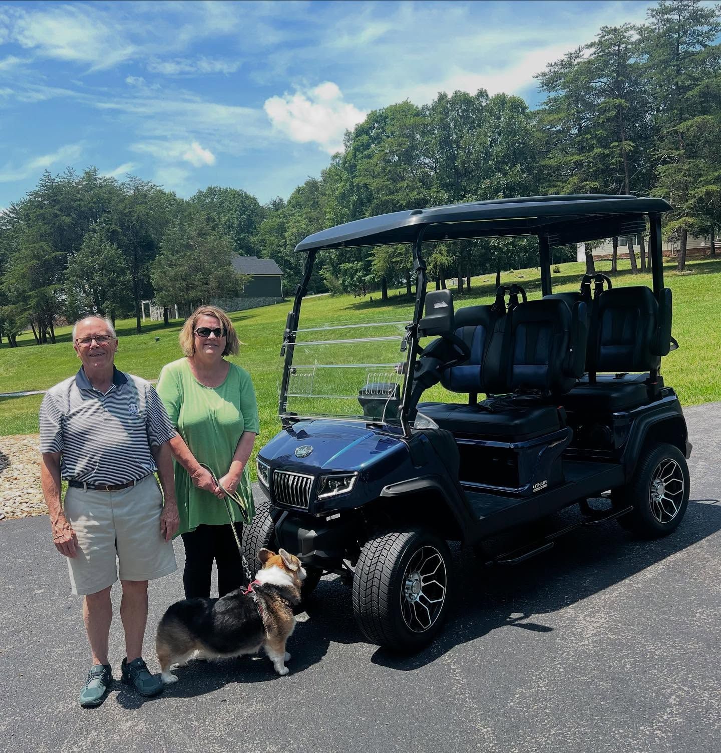 A man and woman standing next to a golf cart