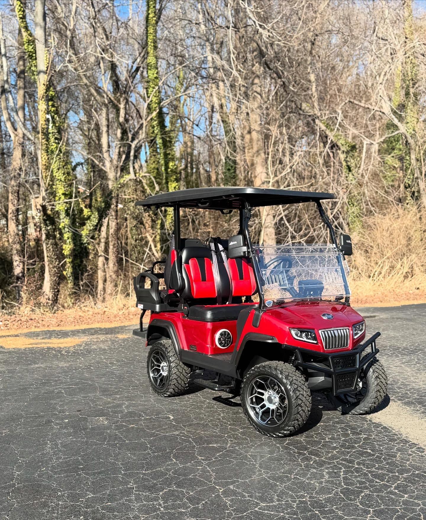 A red golf cart is parked on the side of the road.