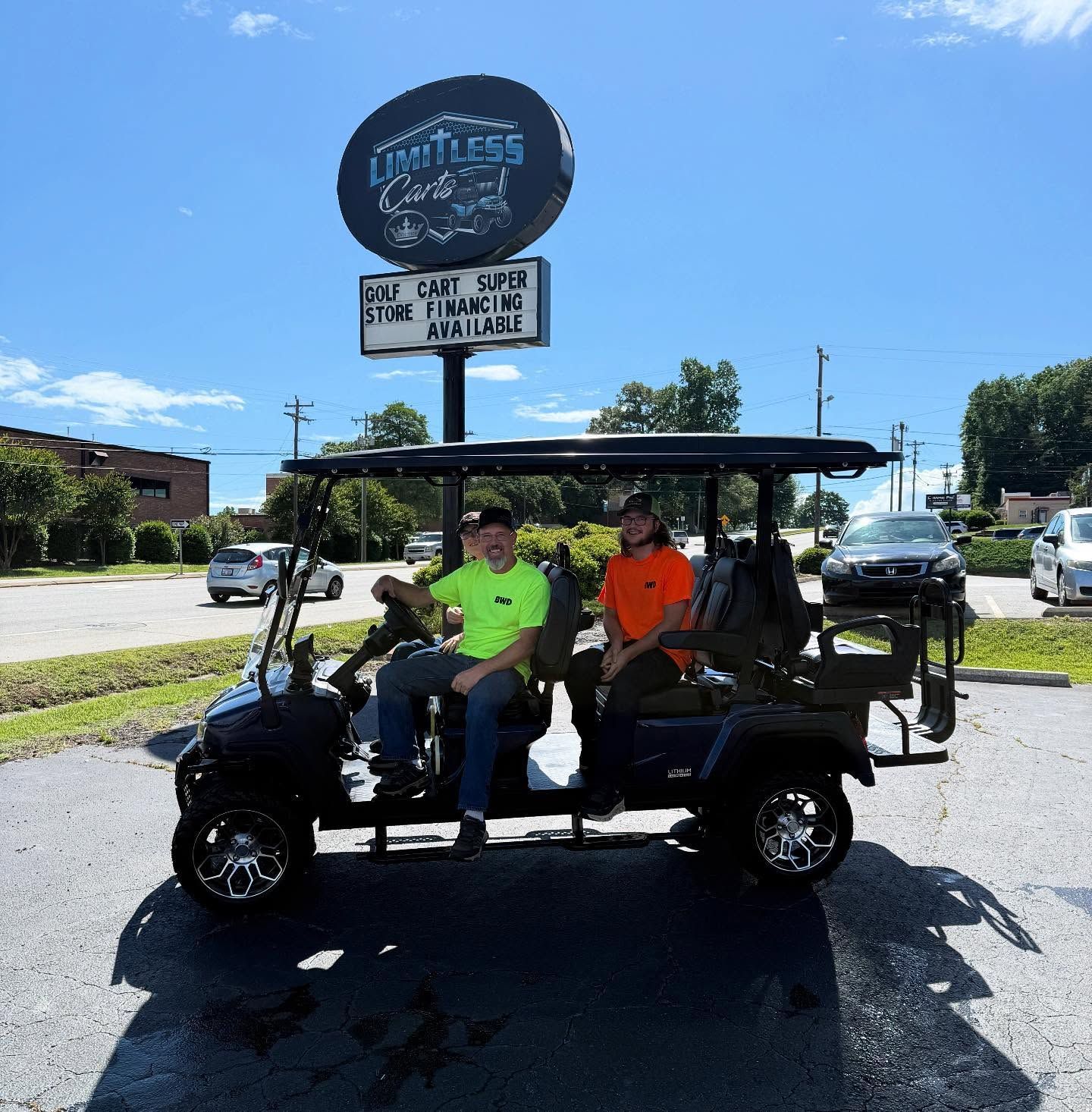 Two men are sitting in a golf cart in front of a golf cart rental sign