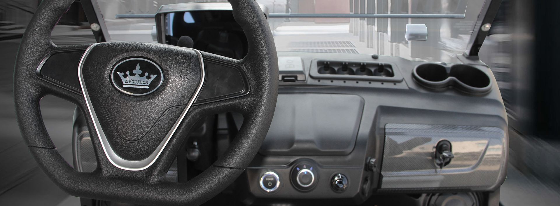 The interior of a golf cart with a steering wheel and dashboard.