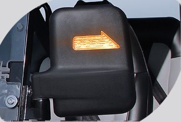 A close up of a car side mirror with an arrow pointing to the right