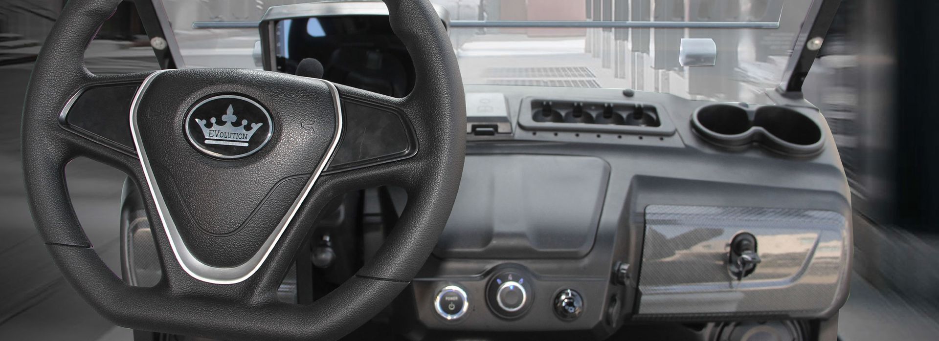 The interior of a golf cart with a steering wheel and dashboard.