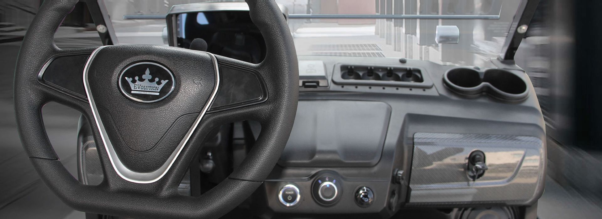 The interior of a golf cart with a steering wheel and dashboard.