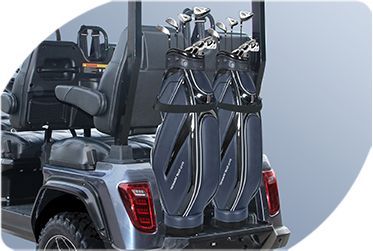 A golf cart with a bunch of golf clubs in the back.