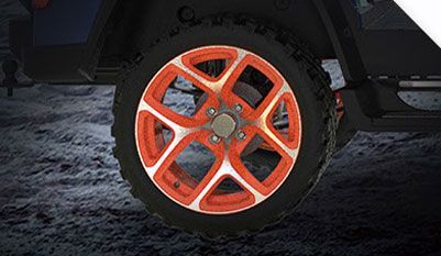 A close up of an orange and white wheel on a car.