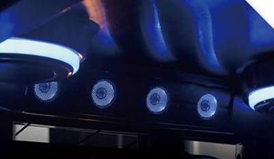 A close up of a ceiling with speakers and blue lights.
