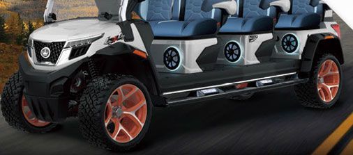 A white golf cart with four seats is driving down a road.