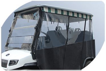 A golf cart with a clear windshield and a green and white striped roof.