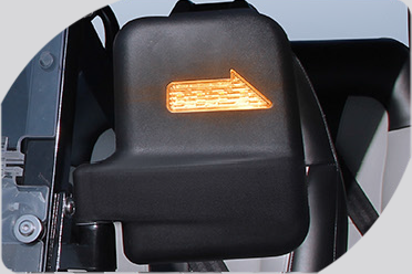 A close up of a car side mirror with an arrow pointing to the right