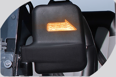 A close up of a car side mirror with an arrow pointing to the right