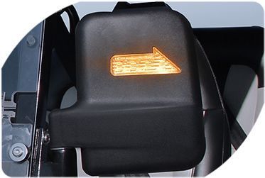 A close-up of a side view mirror with an arrow pointing to the right.