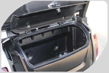 A storage trunk of a golf cart with the lid open.