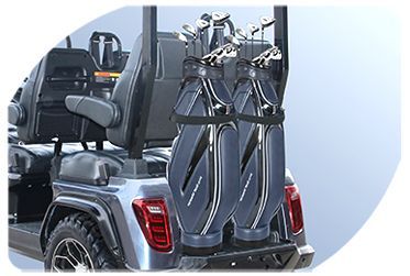 A golf cart with two golf bags attached to the back of it.