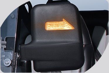 A close up of a car side mirror with an arrow pointing to the right