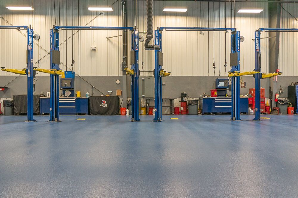 A row of blue lifts in a garage with a blue floor.