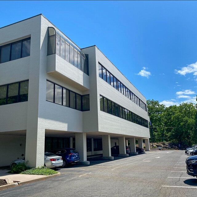 A large white building with cars parked in front of it