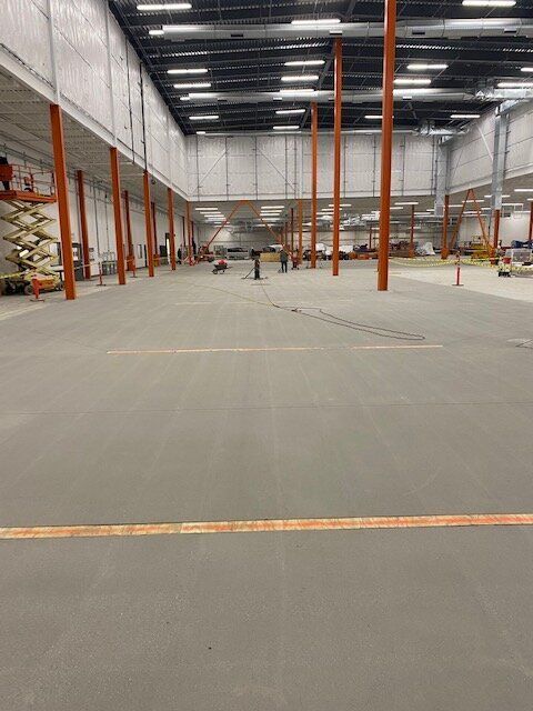 A large empty warehouse with a concrete floor and columns.