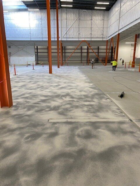 A large empty brewery with a concrete floor