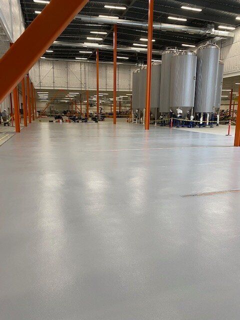 A large brewery with a lot of tanks on the floor.