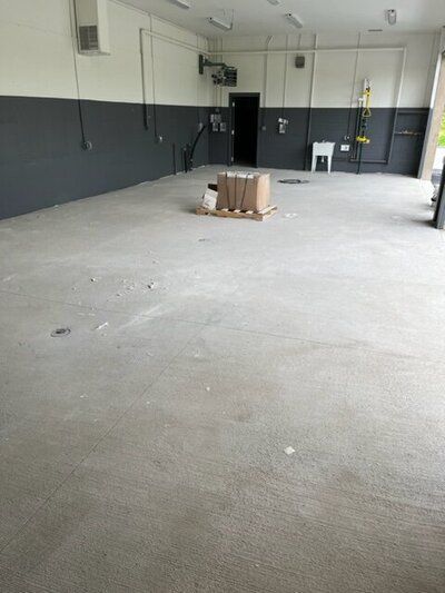 A large empty room with a cardboard box on the floor.