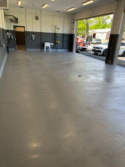 A large empty golf facility with cars parked in it.