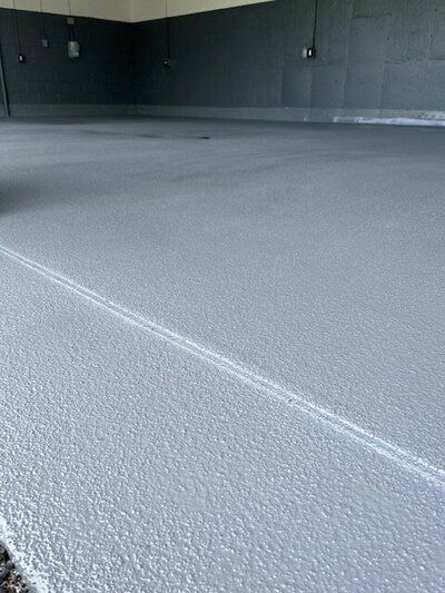 A close up of a gray concrete floor in a golf facility.