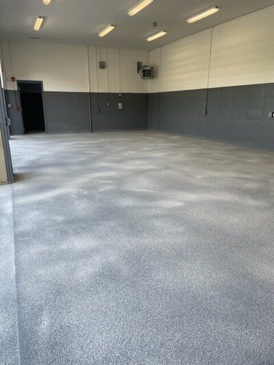 A close up of a gray concrete floor in a golf facility.