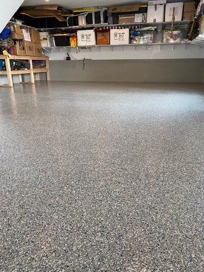 A garage floor with a lot of shelves and boxes on it.